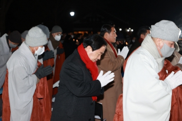 주광덕 남양주 시장(빨간 목도리)이 지난해 12월 31일 진접읍 봉선사에서 기도하고 있다(사진=남양주시)