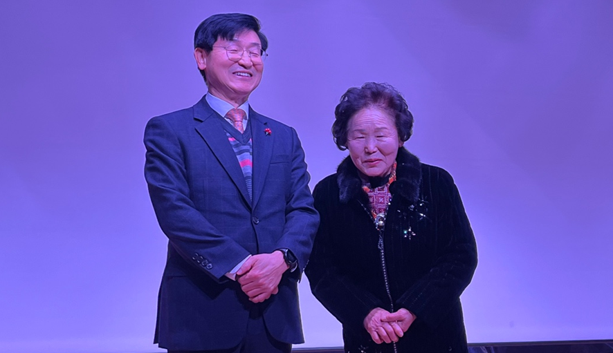 박용호 전 마산지청장이 어머니와 함께 무대에 올라 축하 차 참석한 이들에게 감사의 인사를 하고 있다./ 김 욱기자