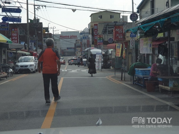 경화시장 보행로가 없어 시민이 중앙선으로 걷고 있다.