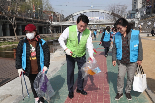 박준희 관악구청장이 자원봉사자들과 별빛내린천에서 쓰레기를 줍고 있다.